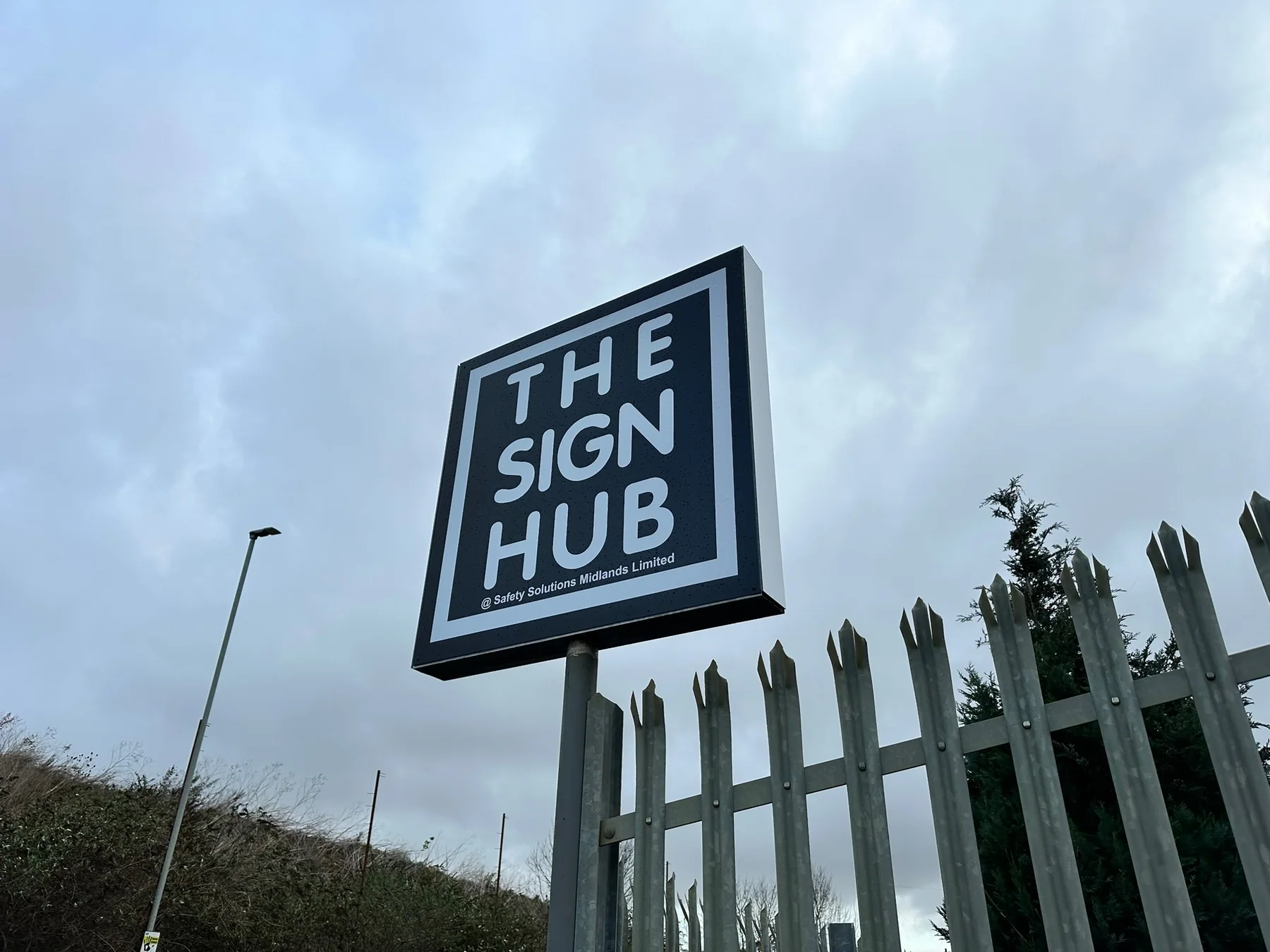 The Sign Hub square roadside sign photographed against an overcast sky