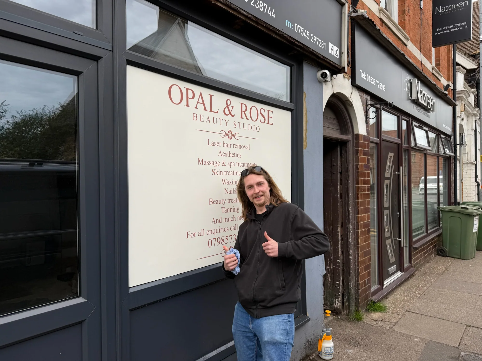 Sign fitter beside the completed Opal and Rose window information panel
