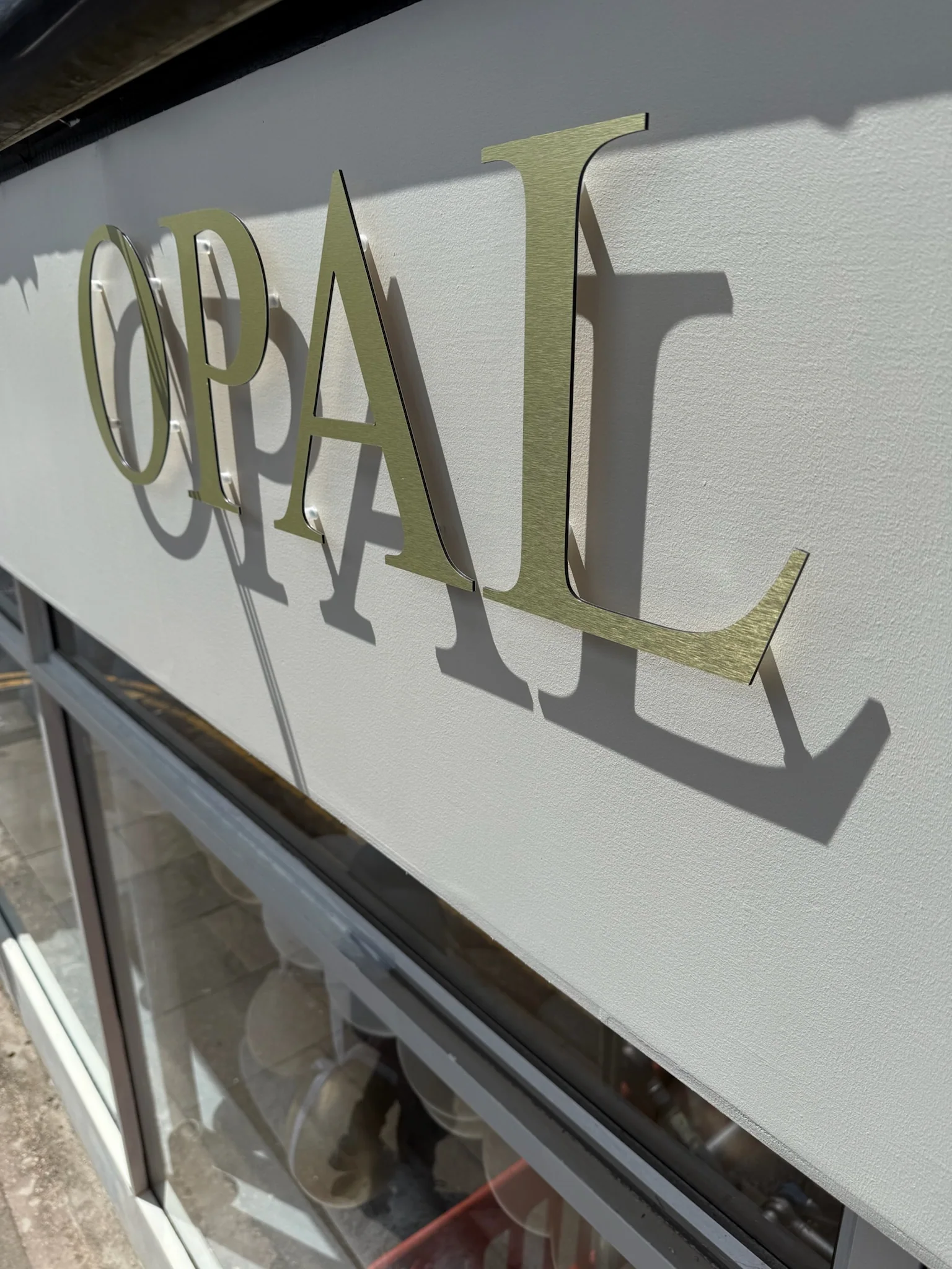 Close-up of dimensional metallic Opal lettering mounted to the shopfront fascia