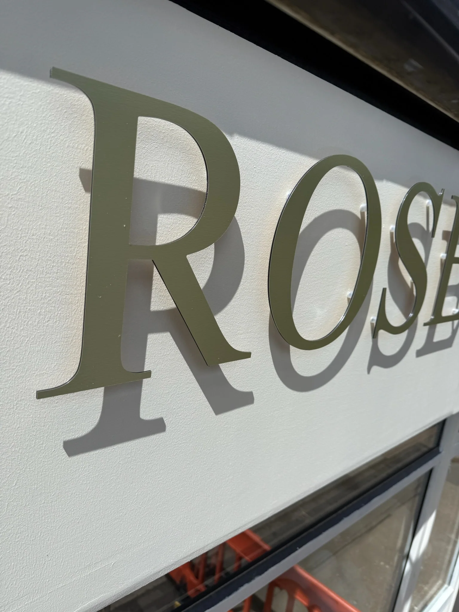 Close-up of the dimensional Rose shopfront lettering and its natural shadow
