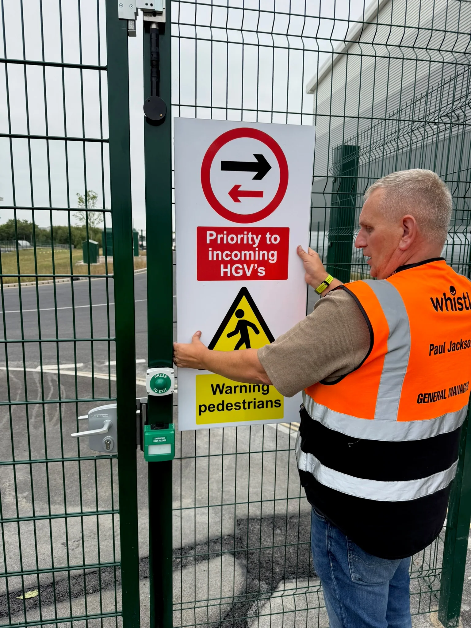 Whistl site worker positioning a priority to incoming HGVs sign